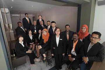 MENDEKATI PELANGGAN: Ejen hartanah dari OrangeTee & Tie, termasuk Cik Roza (bertudung, duduk) dan Encik Azan (empat dari kanan) ingin meningkatkan pengetahuan masyarakat mengenai hartanah. - Foto BH oleh ALPHONSUS CHERN