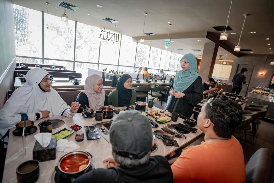 Pemilik restoran, Jing Hotpot & BBQ, Sharifah Noor Aishah Albukhary (berdiri), berinteraksi dengan mereka yang hadir di restorannya di Kinex.