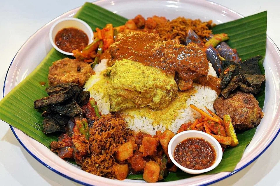 NASI AMBENG: Cara menjamu Nasi Ambeng (gambar atas), nasi putih yang disaji di atas dulang beralaskan daun pisang dan dikelilingi lauk-pauk, sangat menitikberatkan tatatertib. - Foto fail