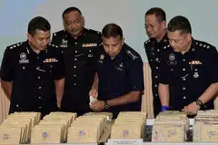 BANTERAS SINDIKET: Ketua Polis Johor, Pesuruhjaya Ayob Khan Mydin Pitchay (tengah) melihat dadah yang dirampas menerusi penemuan sindiket dadah yang dikendalikan sebuah keluarga tujuh anggota. - Foto BEN TAN/MALAY MAIL 