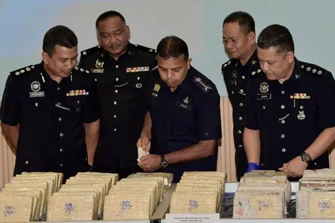 BANTERAS SINDIKET: Ketua Polis Johor, Pesuruhjaya Ayob Khan Mydin Pitchay (tengah) melihat dadah yang dirampas menerusi penemuan sindiket dadah yang dikendalikan sebuah keluarga tujuh anggota. - Foto BEN TAN/MALAY MAIL 