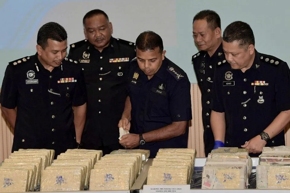 BANTERAS SINDIKET: Ketua Polis Johor, Pesuruhjaya Ayob Khan Mydin Pitchay (tengah) melihat dadah yang dirampas menerusi penemuan sindiket dadah yang dikendalikan sebuah keluarga tujuh anggota. - Foto BEN TAN/MALAY MAIL 