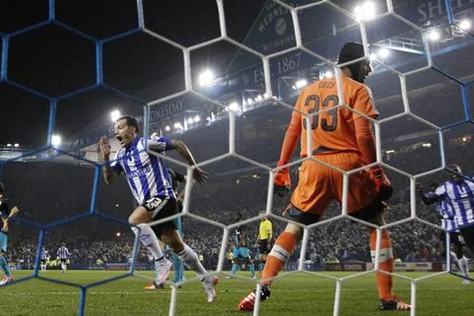 LANGKAH KECUNDANG: Penjaga gawang Arsenal, Petr Cech, gagal menyelamatkan gawangnya dengan pemain Sheffield, Ross Wallace (kiri), berlari kegembiraan meraikan golnya. - Foto REUTERS