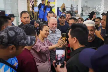 Yang di-Pertuan Agong Malaysia, Sultan Ibrahim (tengah), meluangkan masa beramah mesra dan melayani keterujaan pengunjung restoran Nasi Lemak Wanjo di Kampung Baru, Kuala Lumpur, ketika beliau turun bersarapan di situ pada cuti umum Ulang Tahun Hari Keputeraan Rasmi Agong, 3 Jun. 