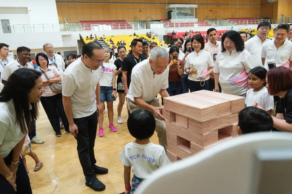 Menteri Kanan, Encik Lee Hsien Loong (tengah) berinteraksi dengan kanak-kanak di Karnival Hari Kanak-Kanak Teck Ghee pada 29 September. 
