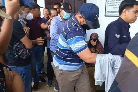 Dua daripada lima warden enjara Taiping, Perak, (bertopi dan berpenutup muka) yang didakwa di Mahkamah Majistret Taiping, pada 3 Julai, atas pertuduhan mencederakan banduan.
