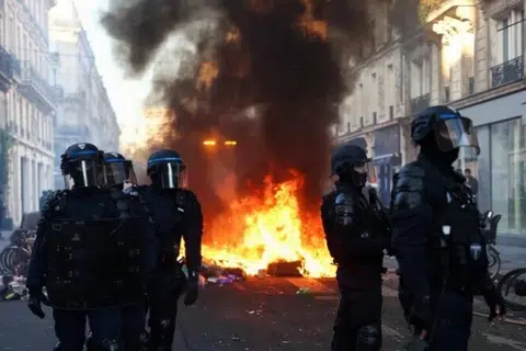 Api marak ketika anggota polis berpakaian lengkap dengan peralatan kawalan rusuhan mengawal semasa gangguan pihak awam di Paris, Perancis, pada 18 Oktober.