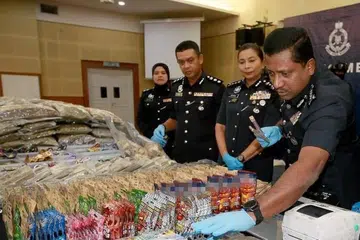 Ketua Polis Selangor, Datuk Hussein Omar Khan (kanan), menunjukkan rampasan paket makanan ringan disyaki mempunyai campuran ganja semasa sidang media di Ibu Pejabat Polis Kontinjen Selangor, Shah Alam. 