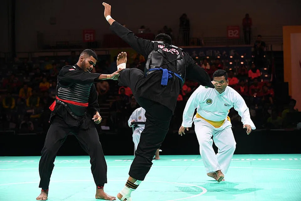 BERJAYA: Sheik Farhan Sheik Alau'ddin (kiri) yang merupakan antara pesilat negara yang berjaya mara ke separuh akhir Kejohanan Pencak Silat Dunia ke-18 beraksi menghadapi lawannya, Ausri Bayusro, dari Indonesia.