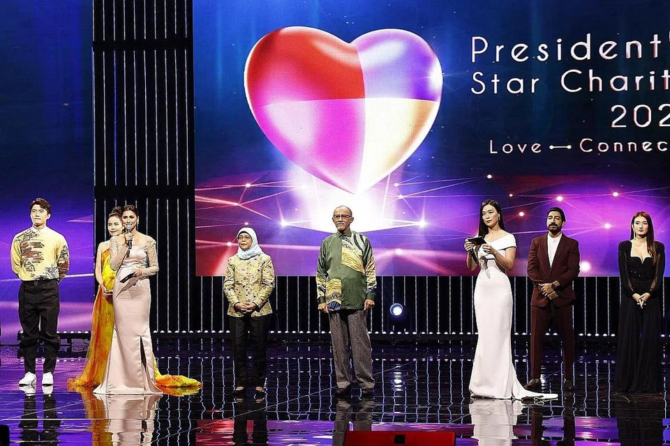 BANTU GOLONGAN MEMERLUKAN: Acara amal 'President's Star Charity' tahun ini berjaya mengumpul $10,902,409. Presiden Halimah Yacob (empat dari kiri) bersama suaminya, Encik Abdullah Alhabshee (empat dari kanan) juga telah turut serta dalam segmen menandatangani lagu tema tahun ini. - Foto MEDIACORP