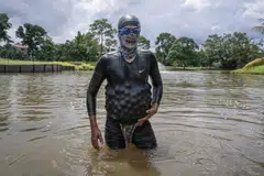 Mantan penyelam Tentera Laut Diraja Malaysia, Encik Sumadi Ibrahim, 51 tahun, memungut bola-bola golf yang tenggelam dan memasukkan ke dalam baju selamnya di tasik padang golf di Shah Alam.