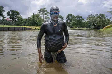Mantan penyelam Tentera Laut Diraja Malaysia, Encik Sumadi Ibrahim, 51 tahun, memungut bola-bola golf yang tenggelam dan memasukkan ke dalam baju selamnya di tasik padang golf di Shah Alam.