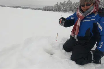 PANCING DI TASIK AIR BATU: Encik Muhammad Yazid semasa melakukan 'ice fishing' iaitu memancing dalam tasik ais semasa beliau bercuti di Finland. Kawasan memancing ini terletak di daerah bandar Rovaniemi.