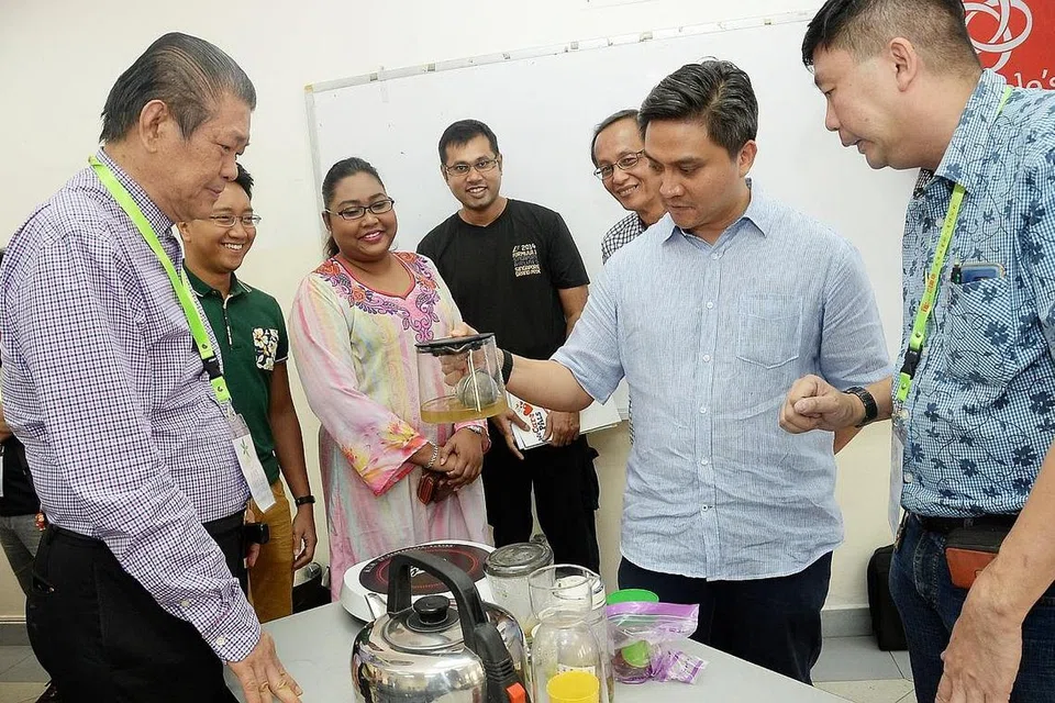TIMBA PENGETAHUAN: Encik Saktiandi (dua dari kanan) melihat teh ginseng sambil diperhatikan oleh penceramah Encik Petter Yee (kanan), Encik Fitri (dua dari kiri), Cik Tasneem (tiga dari kiri) dan suaminya, Encik Abdul Gaffur (berbaju hitam). - Foto JOHARI RAHMAT