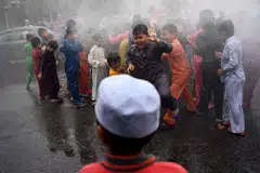 Kanak-kanak lelaki disimbah dengan air sebelum majlis berkhatan beramai-ramai di masjid Bandar Tun Hussein Onn di Kuala Lumpur pada 11 Disember 2016.