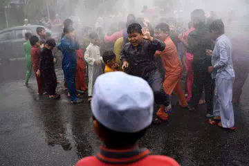Kanak-kanak lelaki disimbah dengan air sebelum majlis berkhatan beramai-ramai di masjid Bandar Tun Hussein Onn di Kuala Lumpur pada 11 Disember 2016.