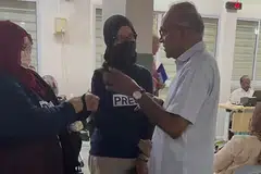 Menteri Ehwal Dalam Negeri merangkap Undang, Encik K. Shanmugam (kanan), berdepan dengan dua wanita yang dikatakan daripada kumpulan aktivis Monday of Palestine Solidarity semasa Sesi Bertemu Penduduk (MPS) di Yishun pada 12 Mac.