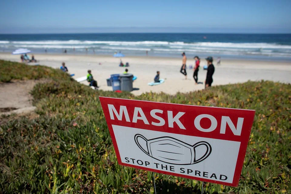 GUNA PELITUP: Papan peringatan diletak di tepi pantai California, Amerika Syarikat yang terdapat banyak kes jangkitan Covid-19 iaitu yang tertinggi dalam sehari. - Foto REUTERS