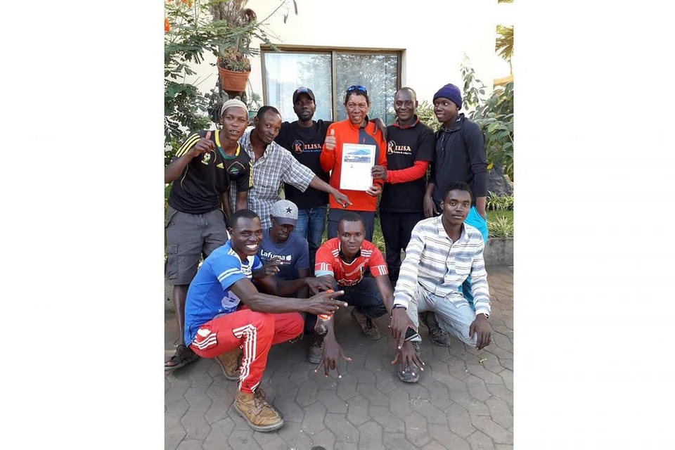 KERJA SEPASUKAN: Penulis (berdiri, tiga dari kanan) meraikan kejayaan bersama Team Kilisa, yang terdiri daripada jurupandu, tukang masak dan tujuh 'porter'. - Foto ihsan MOHAMMAD RAFIE SABARSHAH