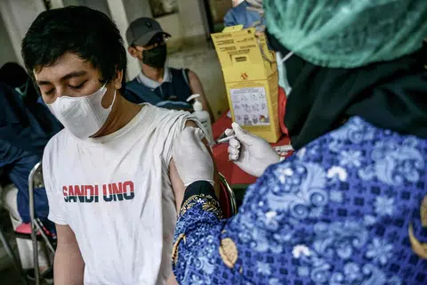 DAPATKAN SUNTIKAN: Pekerja kesihatan menyuntik seorang lelaki dengan vaksin Inavac untuk Covid-19 di Pejabat Kesihatan Wilayah Jakarta pada 19 Disember sedang orang ramai dinasihatkan segera mendapatkan suntikan bagi cegah penularan.