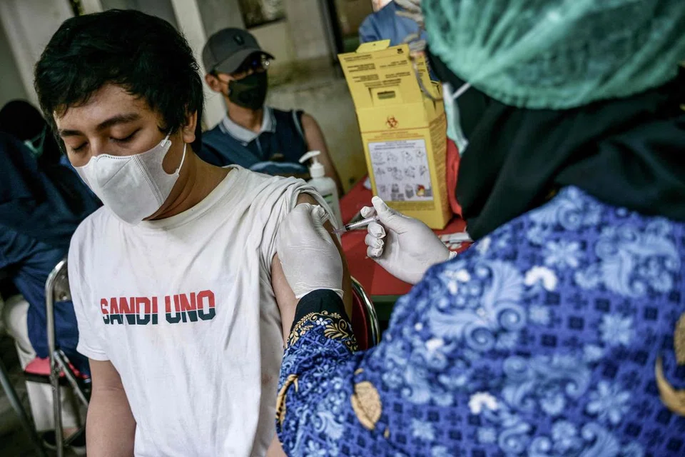 DAPATKAN SUNTIKAN: Pekerja kesihatan menyuntik seorang lelaki dengan vaksin Inavac untuk Covid-19 di Pejabat Kesihatan Wilayah Jakarta pada 19 Disember sedang orang ramai dinasihatkan segera mendapatkan suntikan bagi cegah penularan.