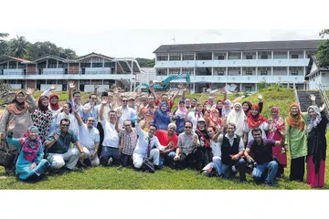 KENANGAN DI SEKOLAH LAMA: Sekumpulan bekas pelajar Sekolah Menengah Sang Nila Utama, termasuk mantan Anggota Parlimen Yatiman Yusof, merakam gambar kenangan di depan sekolah mereka pada 8 September 2014 sebelum bangunan itu dirobohkan. - Foto fail