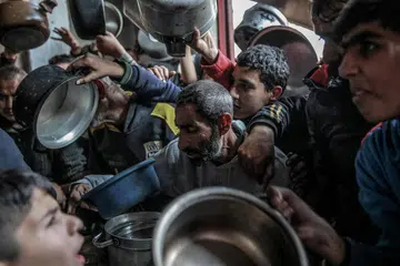 Kanak-kanak Palestin berebut-rebut bagi mendapatkan bantuan makanan yang diagihkan di Beit Lahia, di utara Gaza.