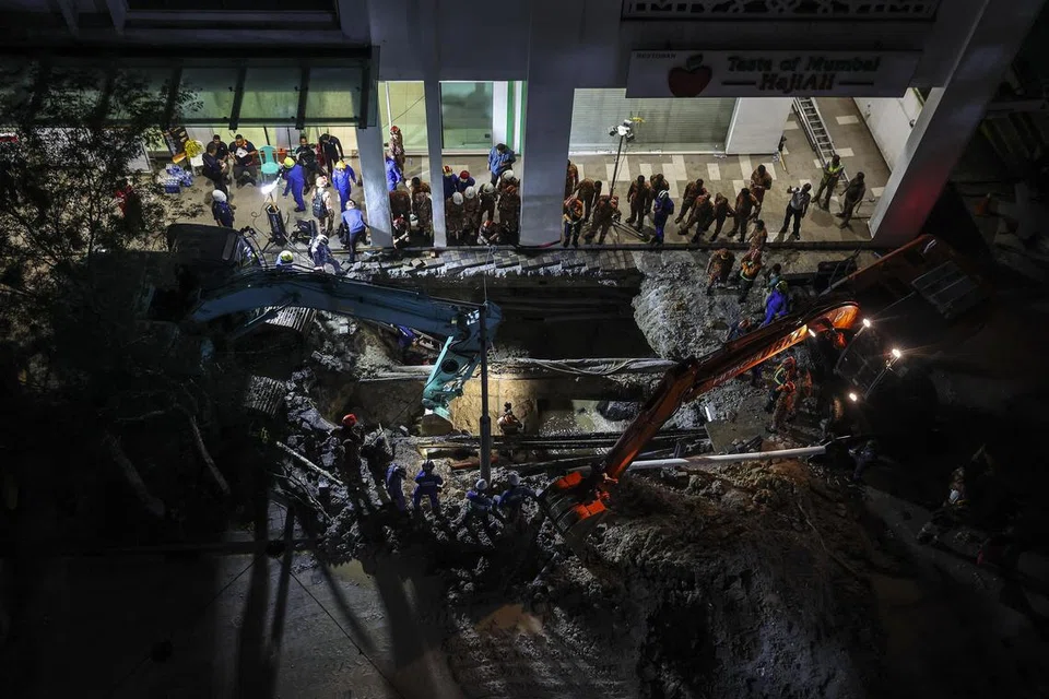 Anggota Jabatan Bomba dan Penyelamat memeriksa tempat di mana seorang wanita terjatuh ke dalam lubang benam sedalam 8 meter di Kuala Lumpur, pada 23 Ogos.