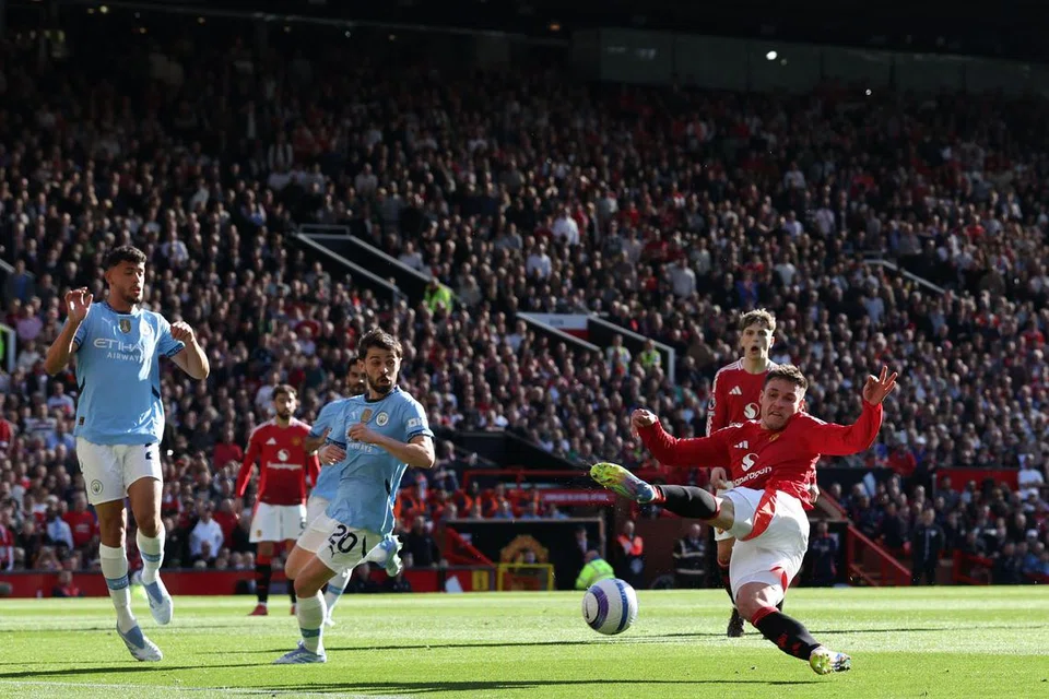 Pemain tengah Manchester United, Manuel Ugarte (kanan) gagal menyambut bola dengan baik pada aksi Liga Perdana England menentang Manchester City di Old Trafford, Manchester.