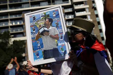 CETUS KEKECOHAN: Penyokong pemain tenis Serbia Novak Djokovic berhimpun di luar Hotel Park, tempat bintang itu dipercayai ditahan semasa beliau berada di Melbourne, Australia. - Foto REUTERS