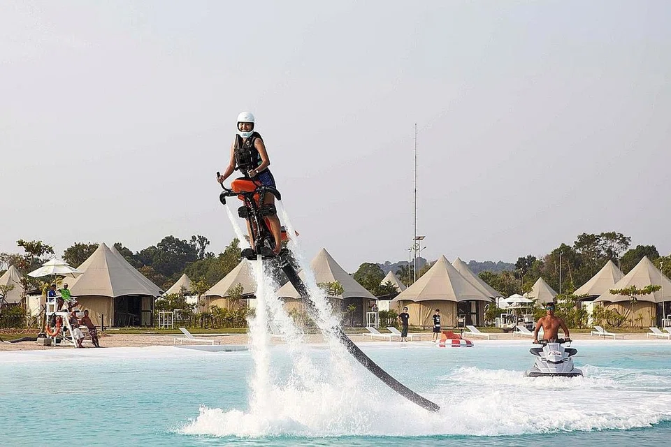 MELUNCUR KE UDARA: Permainan ski kabel membolehkan anda meluncur di atas air dengan bergantung pada kabel. - Foto ZAINAL ABIDIN JAMARI
