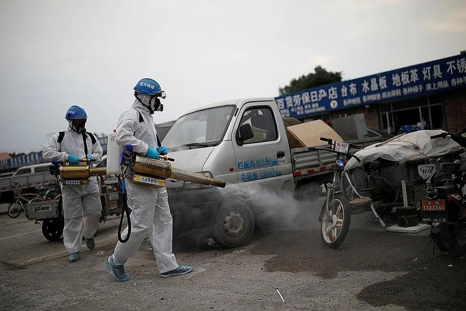 TERUSKAN USAHA BASMI KUMAN: Sukarelawan lengkap dengan pakaian pelindungan menyahjangkit pasar di Nangong, Beijing, bagi mengekang penularan baru jangkitan Covid-19. - Foto REUTERS