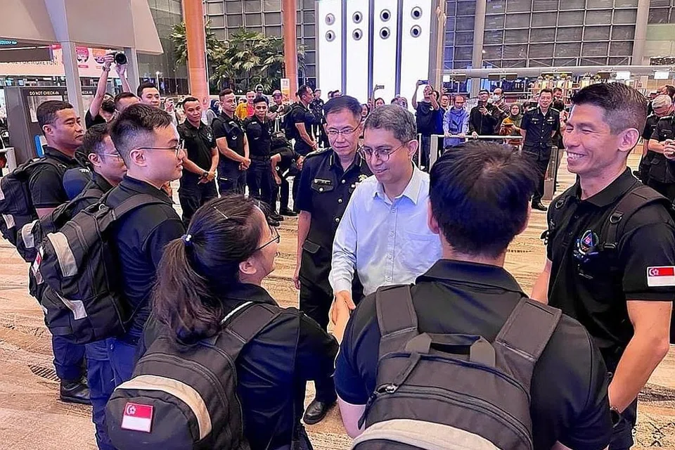 SEDIA HULUR BANTUAN: Dr Faishal (tengah) beramah dengan anggota pasukan respons awal SCDF di lapangan terbang Changi sebelum mereka berlepas. Turut bersama beliau ialah Pesuruhjaya SCDF, Komander Eric Yap (di kanan Dr Faishal), dan ketua kontinjen, LTC Lok Wee Keong (paling kanan). - Foto SCDF