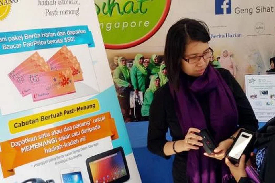 SINGAH KE GERAI KAMI: Pengendali gerai bazar Geng Sihat SG/BH, Cik Sukartini Hashim (kanan) dan Eksekutif Kanan Edaran Singapore Press Holdings (SPH) Cik Nur Nadia Rayhanna Ithnin bersedia menanti pengunjung. - Foto NIZAM ISMAIL