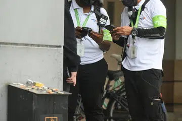 Dua pegawai penguatkuasaan NEA mendekati seorang individu yang ditangkap merokok di kawasan tertutup di pusat beli-belah Causeway Point pada 3 Mei.