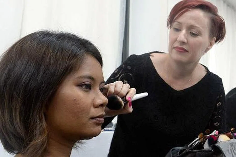 BIMBINGAN KEMBALI BEKERJA: Seorang relawan menunjukkan Cik Nurhasana cara solekan yang sesuai untuk menghadiri temu duga dan untuk ke tempat kerja sebagai sebahagian program Dress For Success. - Foto TAUFIK A. KADER