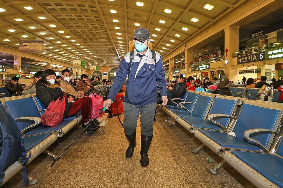 HAPUSKAN KUMAN: Seorang kakitangan melakukan penyahjangkitan di Stesen Kereta Api Hankou di Wuhan semalam. Ratusan juta orang dijangka membuat perjalanan ke serata China bagi cuti Tahun Baru Cina minggu ini. - Foto AFP