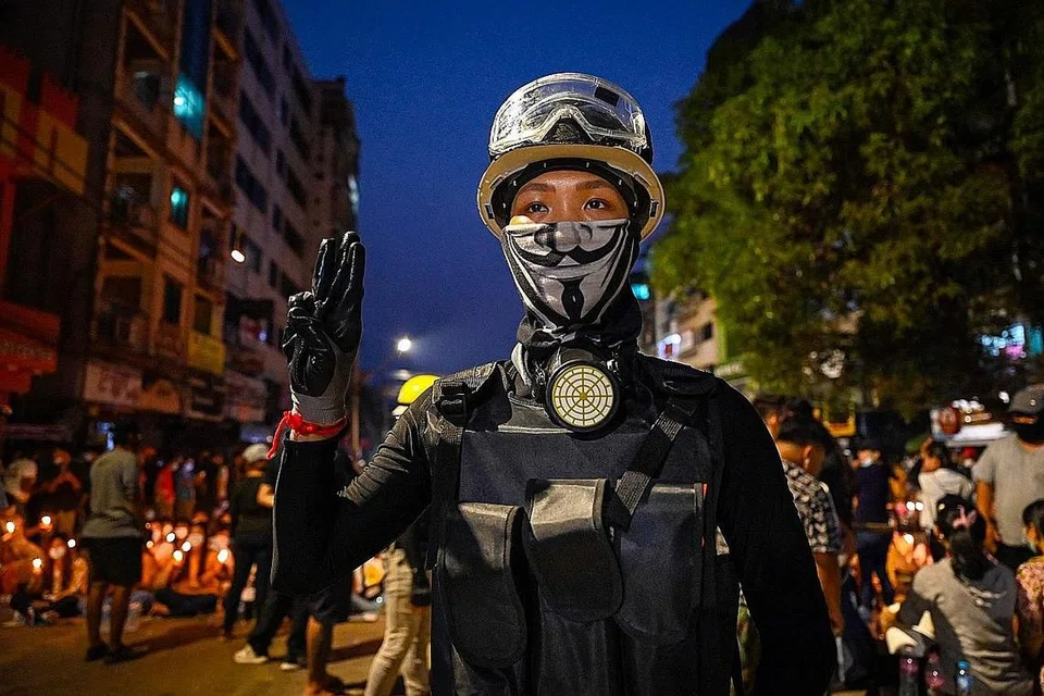 TERUSKAN PERJUANGAN: Seorang penunjuk perasaan menunjukkan lambang tiga jari semasa acara memperingati mereka yang terkorban semasa demonstrasi menentang rampasan kuasa tentera di Yangon. - Foto AFP
