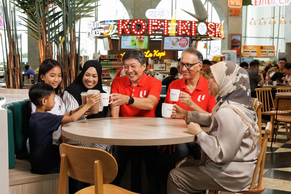Setiausaha Agung, Kongres Kesatuan Sekerja Kebangsaan (NTUC), Encik Ng Chee Meng (tengah), dan Ketua Pegawai Eksekutif (CEO) Kumpulan FairPrice, Encik Vipul Chawla (dua dari kanan), menikmati kopi dan teh panas yang akan ditawarkan pada harga 50 sen sepanjang Mei dan Jun.