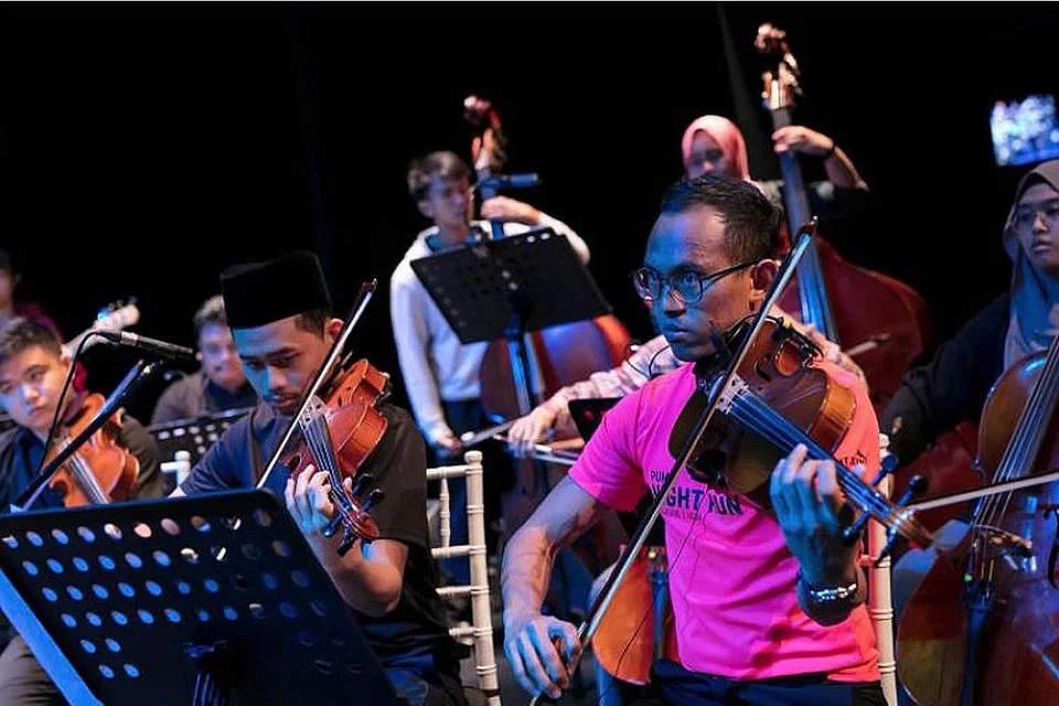 TAHU CARA, TAMBAH CINTA: Encik Syed Ridhwan (kanan) semasa menjalani sesi latihan bersama Orkestra Sri Temasek bagi konsert Rona Irama II pada 2017. Beliau dipelawa menjadi anggota orkestra itu pada 2011 dan dari situ diajar cara bermain lagu tradisional Melayu dan mengenal pasti lenggok yang betul bagi muzik Melayu. - Foto ihsan SYED RIDHWAN AHMAD