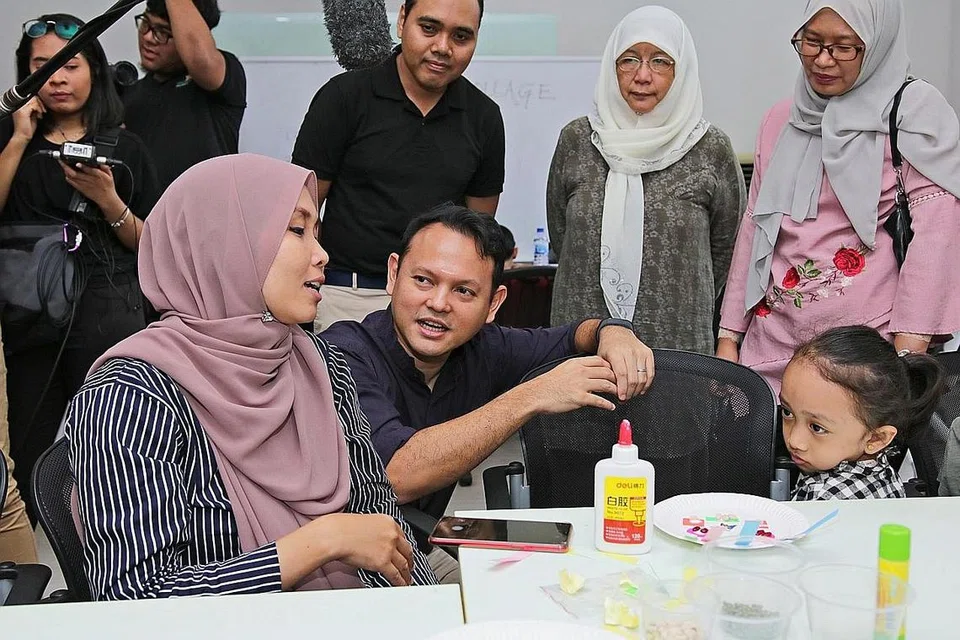 TINGKATKAN KEMAHIRAN MATEMATIK: Cik Maizatul Akmam Mayer (kiri) menghadiri KelasMateMatika (KMM) @ Keat Hong bersama anaknya, Irdina Aisyah Hazley. Menteri Negara (Tenaga Manusia merangkap Pembangunan Negara), Encik Zaqy Mohamad (dua dari kiri ) menyertai mereka dan peserta lain semalam. - Foto BM oleh JEREMY KWAN