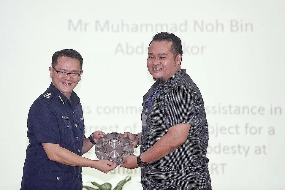 BANTUAN DIIKTIRAF: Encik Muhd Noh Abdul Sukor menerima Anugerah Semangat Awam daripada Komander Divisyen Polis Bedok, Penolong Pesuruhjaya Tan Tin Wee semalam. - Foto BH oleh KEVIN LIM