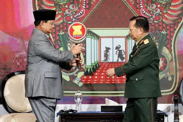 SERAH TUGAS: Menteri Pertahanan Indonesia, Encik Prabowo Subianto, menyerahkan tanda Asean kepada Menteri Pertahanan Laos, Encik Chansamone Chanyalath, semasa upacara penyerahan Mesyuarat Menteri-Menteri Pertahanan Asean di Jakarta pada Khamis.