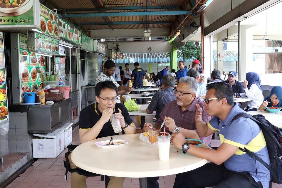  MASIH TERUS DIKUNJUNGI: Pusat penjaja di Blok 4A Woodlands Centre Road ini masih terus menjadi tumpuan pekerja dari Johor Bahru yang datang seawal 5 pagi untuk bersarapan sebelum menjadi lebih lengang di waktu tengah hari. - Foto SHAHRIYA YAHAYA