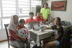 KONGSI RUANG KERJA: Bagi memastikan jadual kelas dalam talian dipatuhi anak-anaknya serta disiplin mereka dijamin, Cik Noraini Mas Noraini Wahid tidak mengizinkan anaknya belajar di bilik sendiri dan hanya duduk di meja makan bersama suaminya. - Foto-foto BH oleh AZMI ATHNI