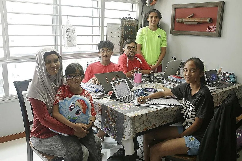 KONGSI RUANG KERJA: Bagi memastikan jadual kelas dalam talian dipatuhi anak-anaknya serta disiplin mereka dijamin, Cik Noraini Mas Noraini Wahid tidak mengizinkan anaknya belajar di bilik sendiri dan hanya duduk di meja makan bersama suaminya. - Foto-foto BH oleh AZMI ATHNI