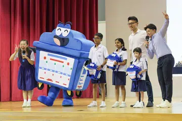 Setiausaha Parlimen Kanan (Kemampanan dan Sekitaran), Encik Baey Yam Keng (dua dari kanan) bersama maskot kitar semula, Bloobin, dan pelajar Sekolah Rendah Unity semasa pelancaran kempen ‘Recycle Right 2024’.