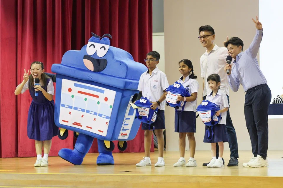 Setiausaha Parlimen Kanan (Kemampanan dan Sekitaran), Encik Baey Yam Keng (dua dari kanan) bersama maskot kitar semula, Bloobin, dan pelajar Sekolah Rendah Unity semasa pelancaran kempen ‘Recycle Right 2024’.