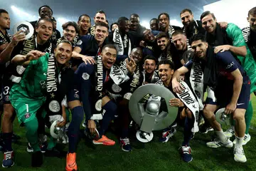 Penyerang PSG, Kylian Mbappe (barisan depan, dua dari kiri), meraikan bersama rakan sepasukannya trofi kejuaraan Ligue 1 Perancis selepas aksi menentang Toulouse di Parc des Princes, Paris, pada pagi 13 Mei.  