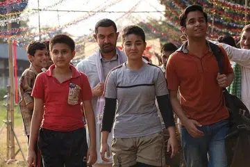 SUNTIK INSPIRASI: Aamir Khan (tengah, berjanggut) berlakon sebagai ahli gusti pesara dalam filem 'Dangal', bersama watak anak-anak perempuan yang dilatih bergusti lalu berjaya dalam arena yang lazimnya dikuasai lelaki. - Foto DANGAL